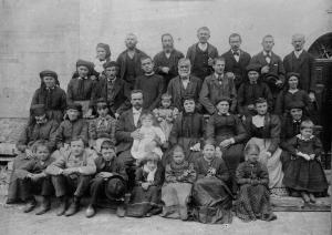 Bambini, giovani e anziani in posa col loro parroco per una foto di gruppo